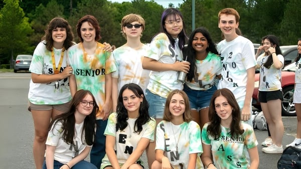 Un grupo de estudiantes se agrupa al aire libre en el terreno del Hopkinton Public School District.
