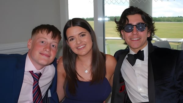 Tres personas posan juntas en un espacio formal en el campus de la Howard of Effingham School con vista al paisaje.