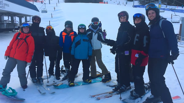 Un grupo de estudiantes de la Hugh Boyd Secondary School está con equipo de esquí en una pendiente nevada.