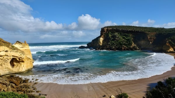 Un paisaje costero pintoresco con playa de arena y acantilados frente al edificio de la Hunters Hill High School.