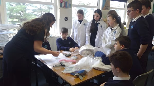 Estudiantes del Iascaigh College investigan juntos varios objetos en un experimento.