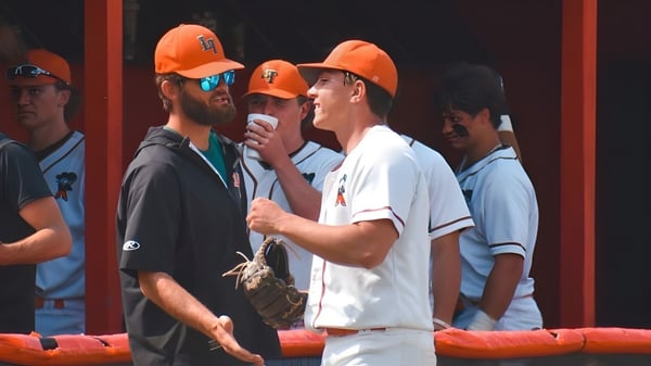 Estudiantes de Illinois Eastern Community Colleges llevan cascos naranjas y discuten en una obra.