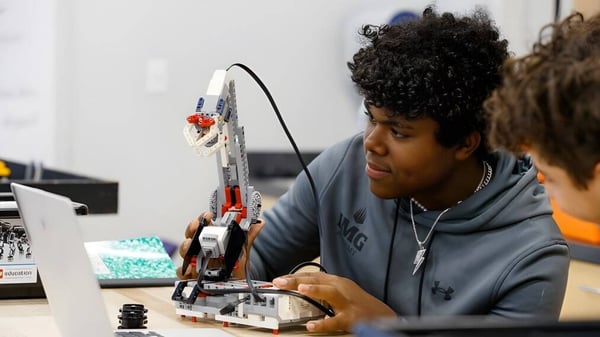 Un estudiante de la IMG Academy se concentra en la clase de taller en el ensamblaje de un dispositivo mecánico.
