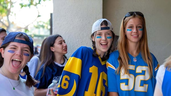 Un grupo de estudiantes de la Immaculate Heart High School celebra en camisetas deportivas durante una competencia.