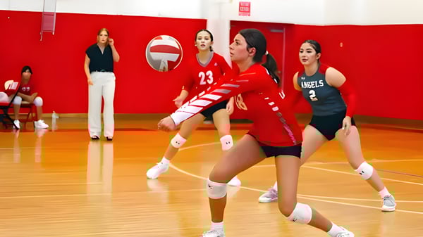 Jugadoras de voleibol de la Incarnate Word Academy se preparan en el gimnasio para la siguiente jugada.