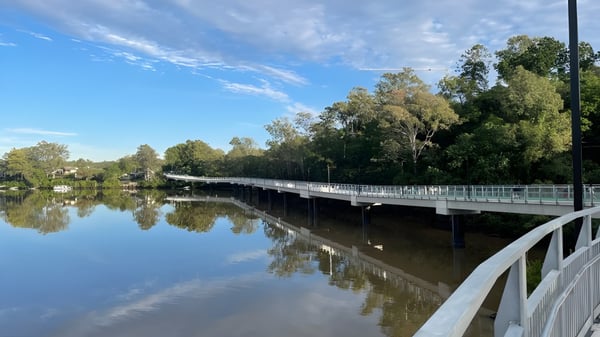Un puente de madera sobre un agua tranquila en el terreno de la Indooroopilly State High School.