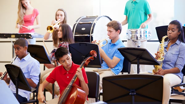 Un grupo de estudiantes de la Indooroopilly State High School toca diferentes instrumentos musicales en el aula.