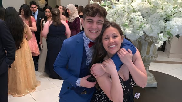 Un grupo de estudiantes de la Iroquois Ridge High School posan juntos en un ambiente festivo con decoración floral.