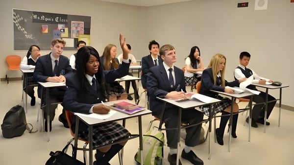 Un grupo de estudiantes de la J. Addison School está sentado en uniformes escolares en el aula con materiales de enseñanza y carteles educativos.