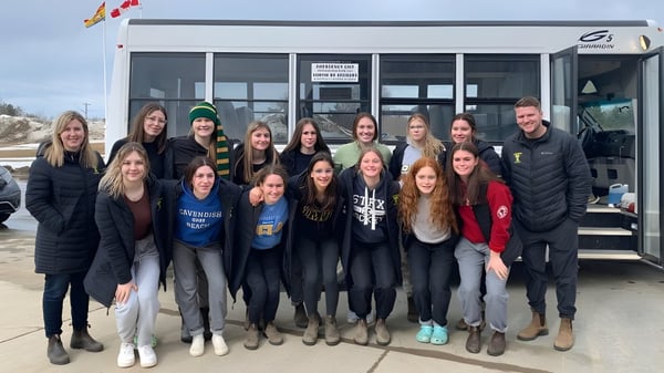 Un grupo de estudiantes está frente al edificio de la James M. Hill Memorial High School.