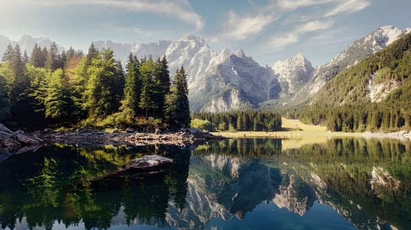 El lago alpino con montañas cubiertas de nieve y bosques de coníferas refleja el paisaje en el John Abbott College.