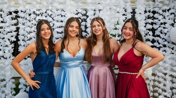 Cuatro estudiantes de la Johnston Heights Secondary School posan juntas frente a un fondo blanco.