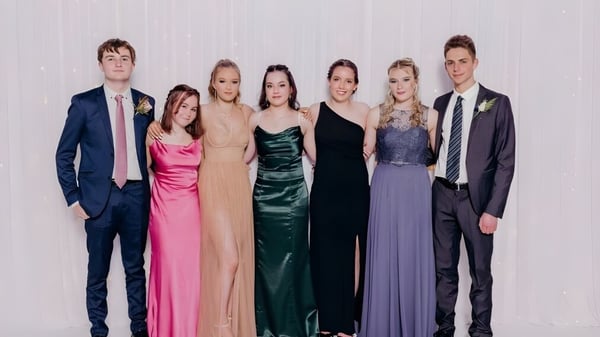 Un grupo de seis personas vestidas de forma formal posan frente a un fondo neutro en el Kaikorai Valley College.