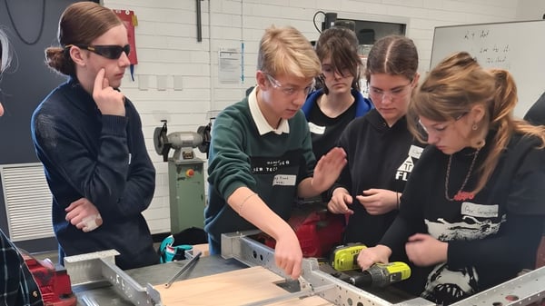 Estudiantes de la Kalamunda Senior High School examinan juntos un dispositivo en el laboratorio.
