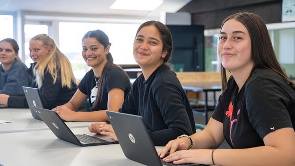 Un grupo de estudiantes de la Kamo High School trabaja concentrado en portátiles en un aula moderna.