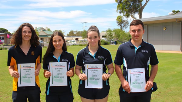 Cuatro estudiantes de la Keith Area School están en un prado sosteniendo certificados en las manos.