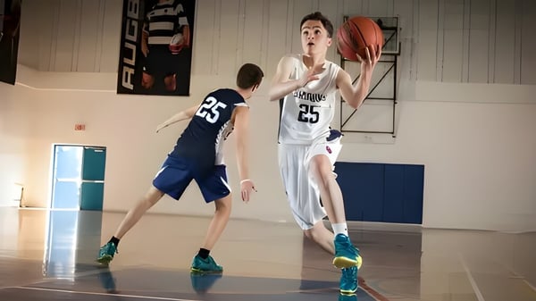 Dos estudiantes de Kells Academy juegan entre sí en la cancha de baloncesto.
