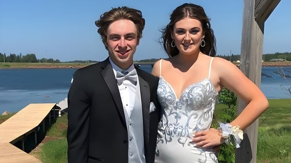 Una pareja está en un muelle de madera junto al agua en el terreno de Kensington Intermediate Senior High School.