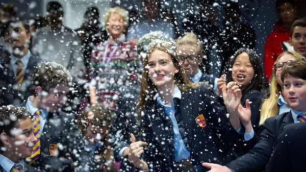 Estudiantes de Kensington Park School celebran juntos con confeti cayendo.