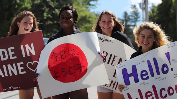 Estudiantes de Kents Hill School sostienen carteles con diferentes mensajes durante una demostración en el parque.