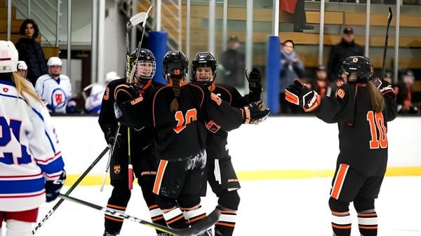 Estudiantes de la Kimball Union Academy juegan hockey sobre hielo frente a espectadores.