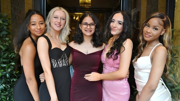 Un grupo de cinco alumnas en atuendo formal están juntas en el recinto de King's Ely.