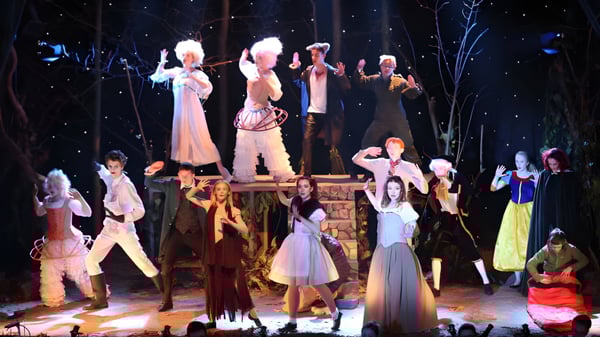 Estudiantes de la King's School Rochester presentan una obra de teatro con elaborados disfraces bajo un cielo estrellado.