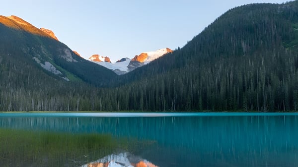 Un tranquilo lago alpino con montañas nevadas y un paisaje boscoso cerca de la Ladysmith Secondary School.
