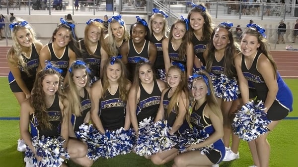 Un grupo de animadoras de Lafayette Christian Academy posan juntas en uniformes uniformes en un campo deportivo.