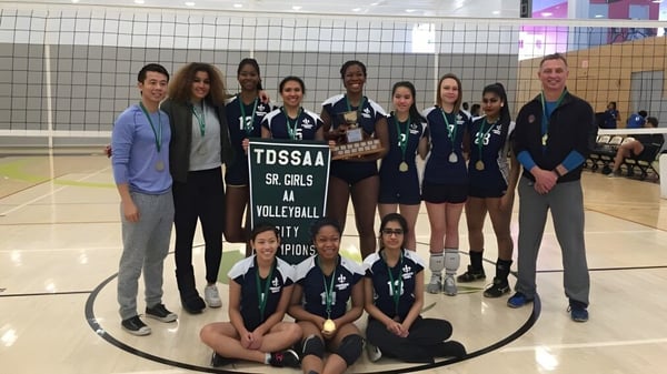 Estudiantes del L'Amoreaux Collegiate Institute posan con el trofeo en el campo de voleibol como campeonas del TDSAA Sr. Girls Volleyball.