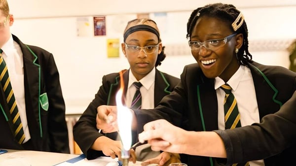 Tres estudiantes de la Langley School están sentados juntos en una mesa y están teniendo una discusión.