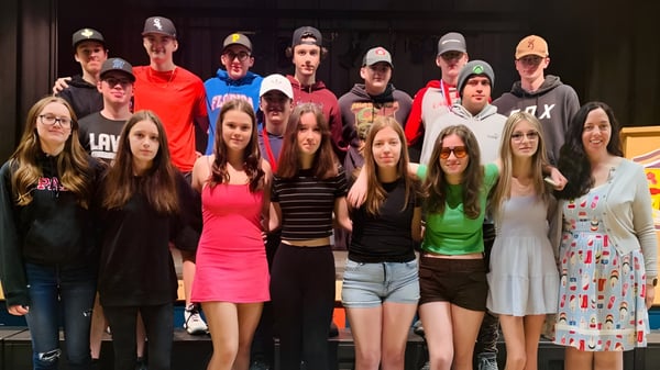 Un grupo de estudiantes está juntos en un escenario en el campus de Laval High School.