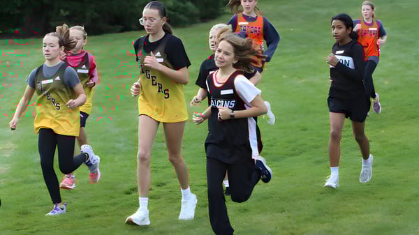 Jóvenes atletas corren juntas en un campo en el campus de la Lethbridge School Division.