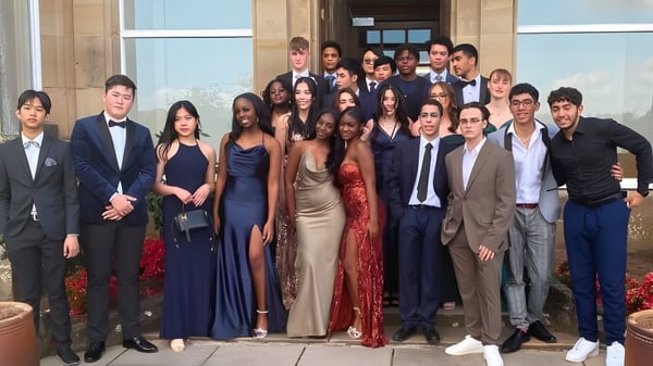 Un grupo de personas posando frente al gran edificio de la Lime House School.