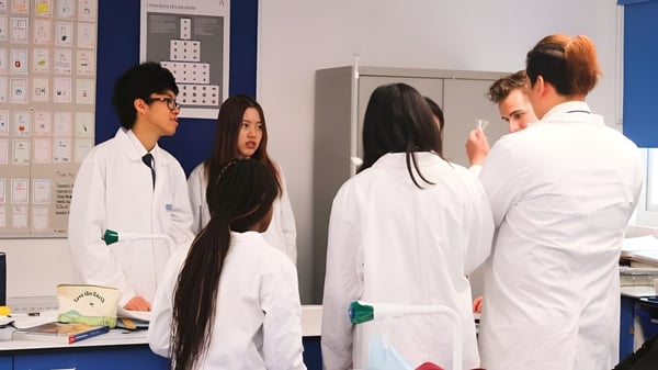 Estudiantes de la Lime House School están en el laboratorio con equipos científicos y material de experimentación.