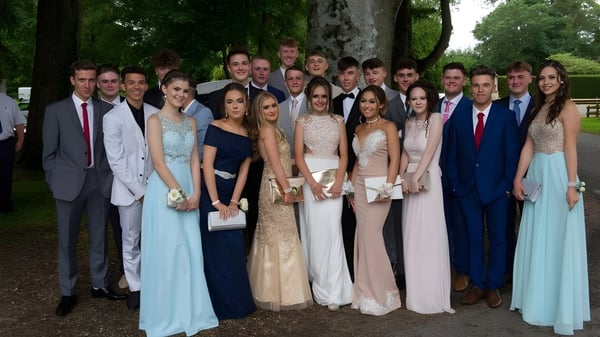 Un grupo de estudiantes de la Lincoln Minster School se reúne afuera frente a árboles y áreas verdes.
