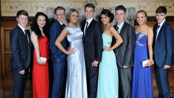 Un grupo de personas vestidas formalmente posan frente a una arquitectura adornada en el campus del Llandovery College.