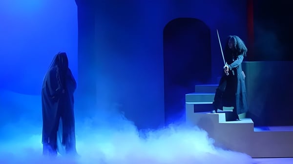 Dos figuras están en el escenario en una neblina azul en el campus de la Loomis Chaffee School.