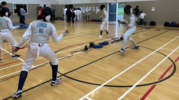Alumnos de la Loreto Abbey Secondary School participan en una competencia de esgrima en el gimnasio.