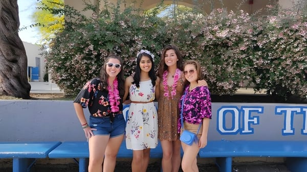 Cuatro estudiantes están frente a un patrón de flores en el terreno del Los Angeles Unified School District.