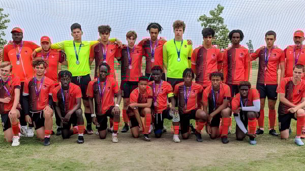 Un grupo de jóvenes futbolistas posan en el campo de la École secondaire publique Louis-Riel frente a una portería.