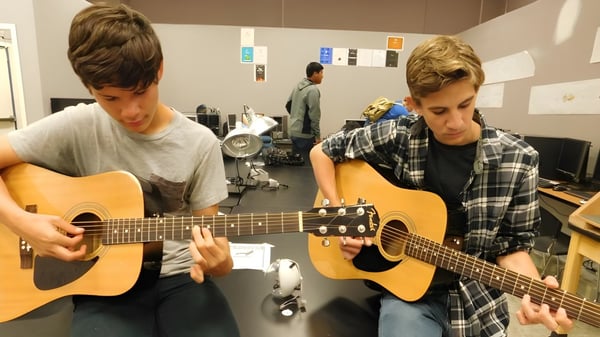Dos estudiantes tocan guitarras acústicas en un aula de música del Loyalist Collegiate & Vocational Institute.