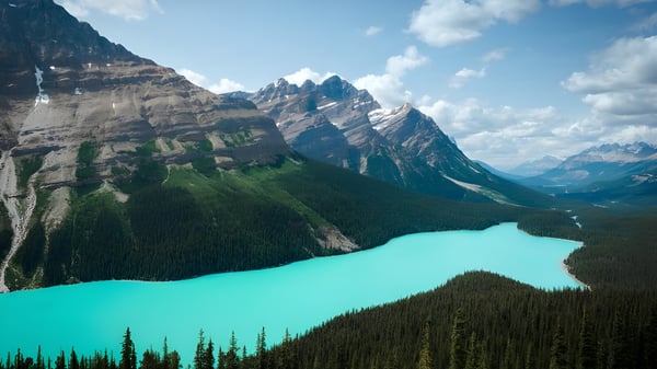 Un impresionante panorama montañoso con picos cubiertos de nieve y un lago turquesa frente al terreno de Luther College High School.