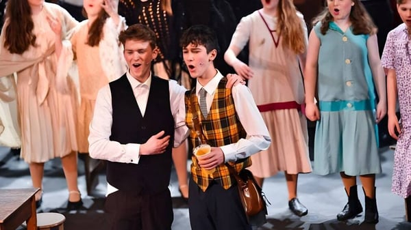 Alumnas y alumnos de LVS Ascot en una actuación en el escenario con ropa formal.