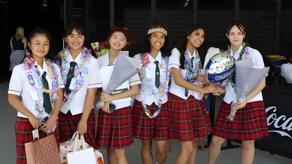 Un grupo de alumnas se encuentra en uniformes escolares japoneses tradicionales en el campus de la MacGregor State High School.