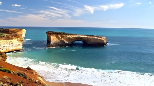 Un impresionante paisaje costero con formaciones rocosas y agua turquesa bajo un cielo azul.