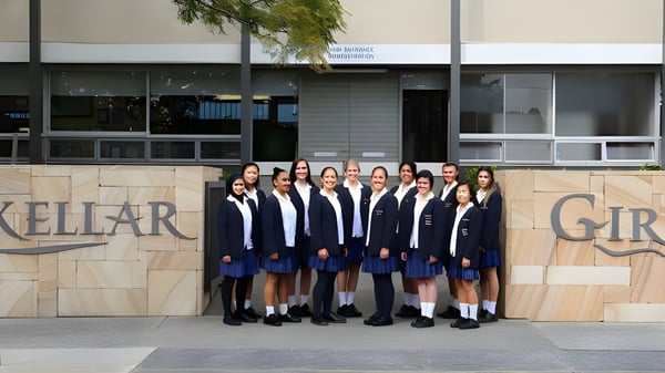 Un grupo de alumnas del Mackellar Girls Campus está de pie frente a un edificio con la inscripción Mackellar Girls.