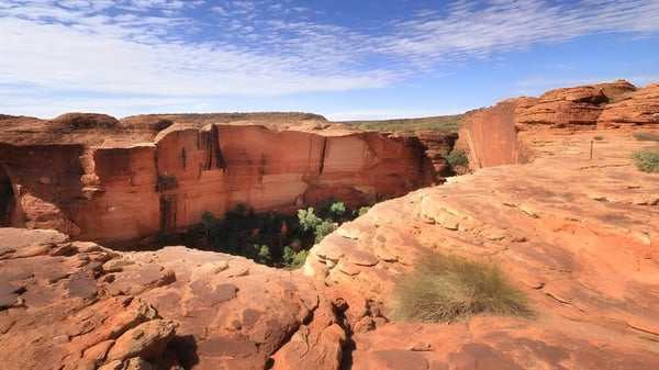 Formaciones rocosas en el paisaje desértico bajo un cielo azul cerca de la Malanda State High School.