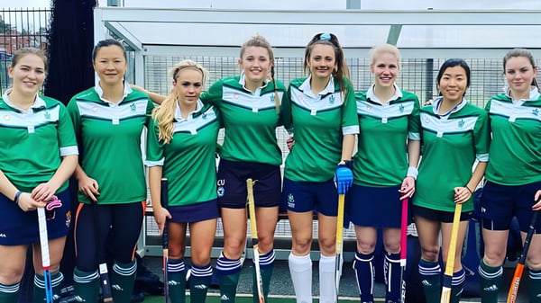 Un grupo de atletas está frente al campo deportivo cercado en el campus del Malvern College.