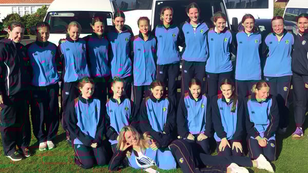 Un grupo de estudiantes en uniformes azules está junto al edificio del Manawatu College.